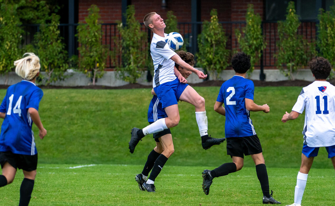 A SMUS player jumps in the air to take control of the ball on his chest