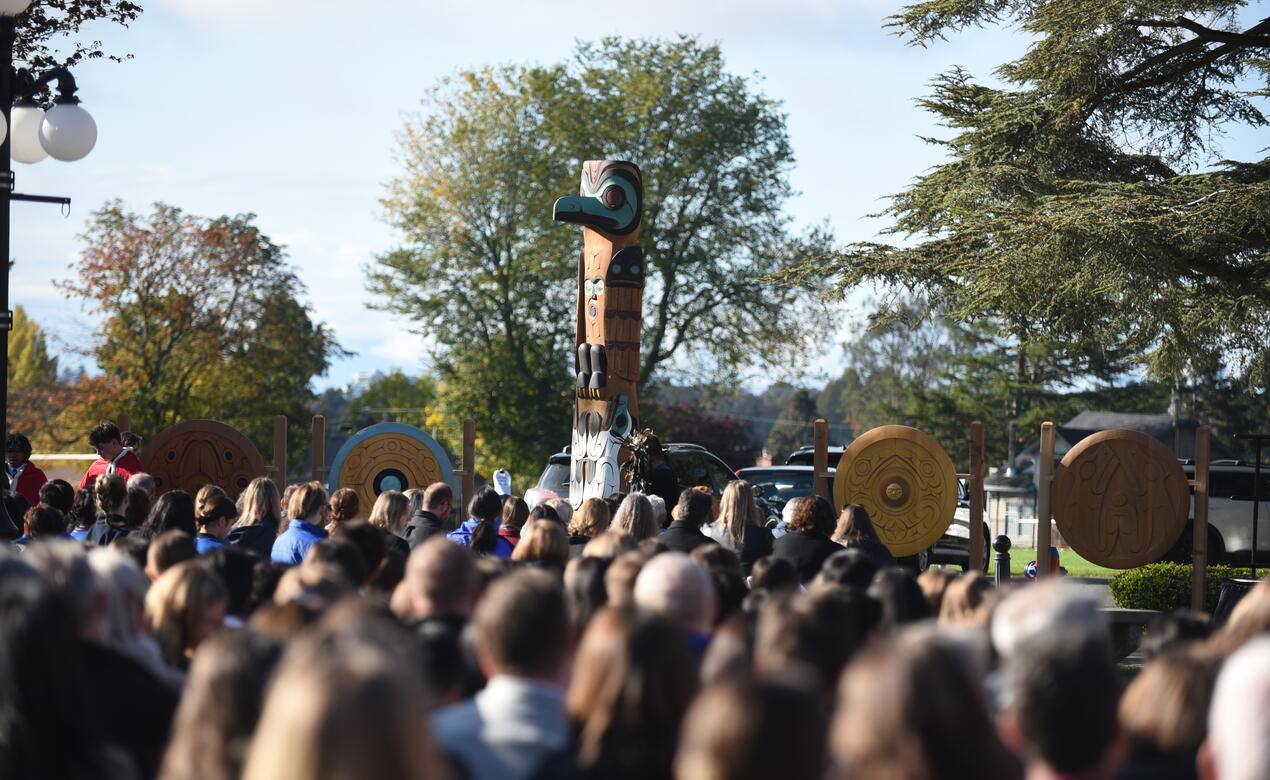 A large crowd of students look on to the Welcome Pole unveiled at the Richmond Road campus. 