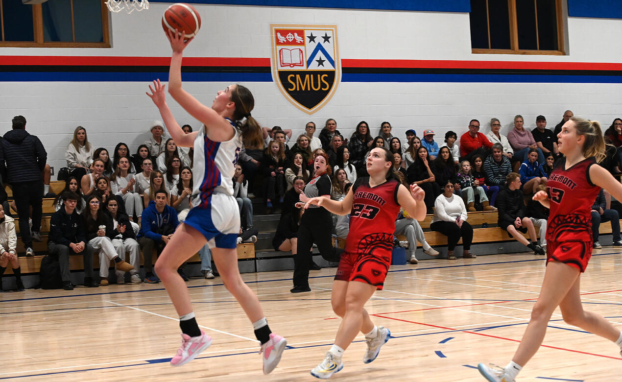 A SMUS player evades the opposition and makes a layup to take the basket