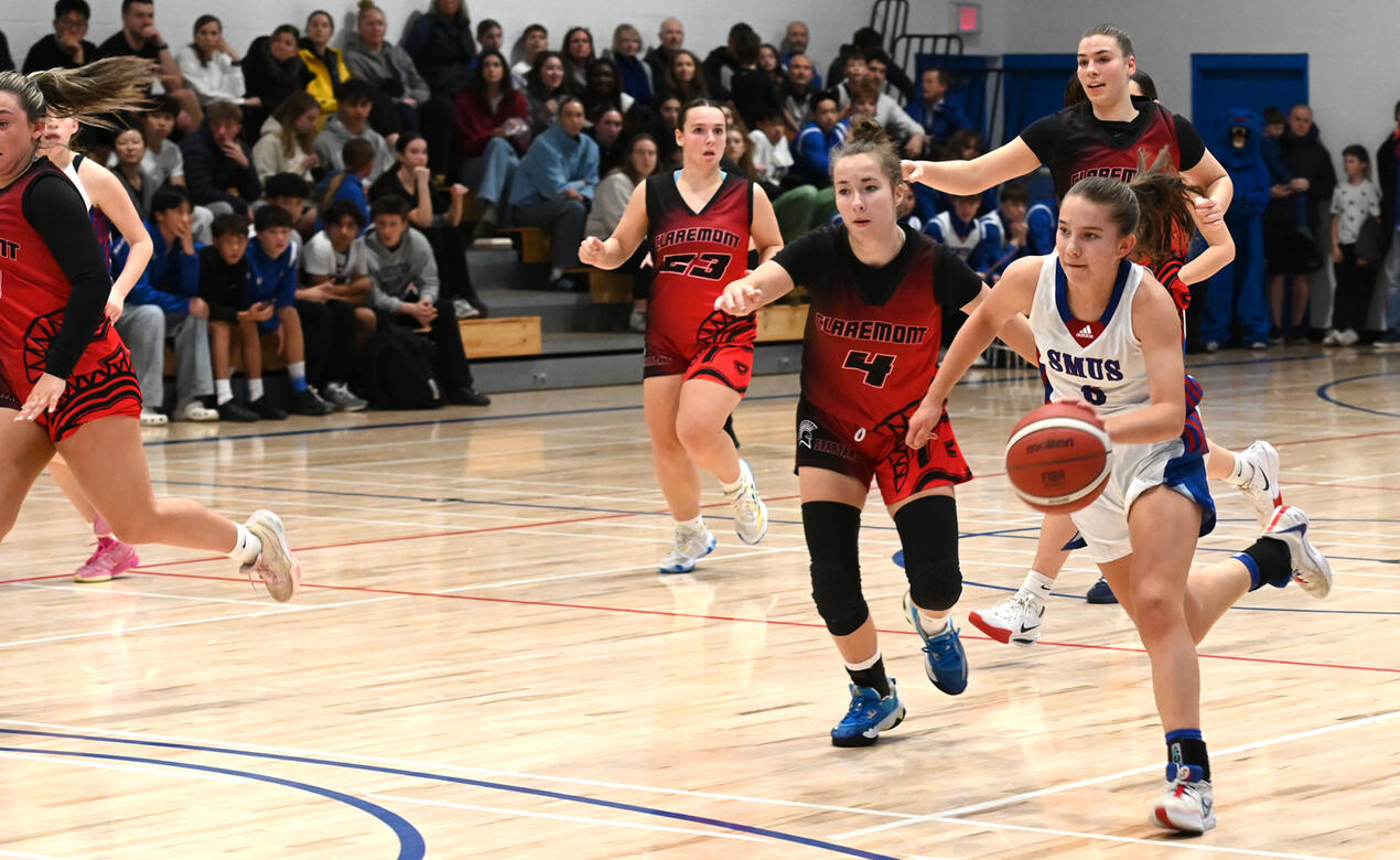 A SMUS player runs around opposing players while dribbling the ball