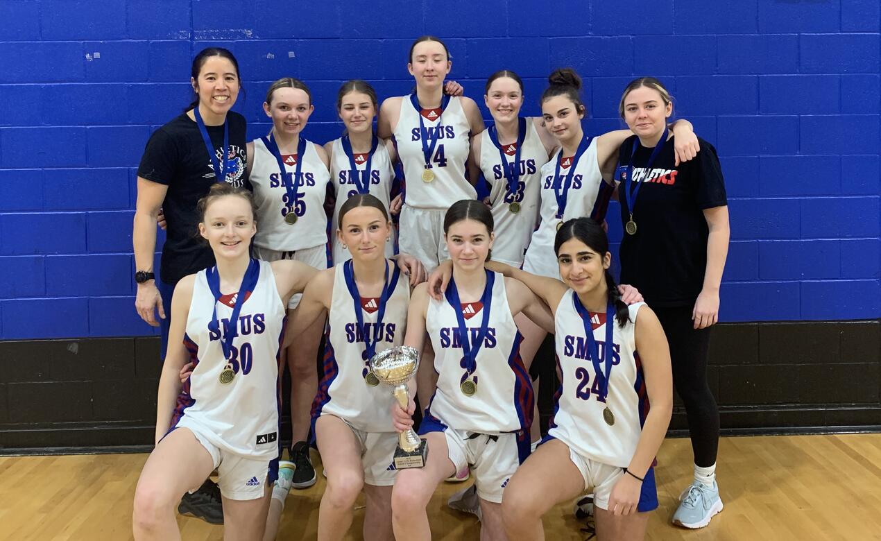 Junior Girls Basketball were Island Champions and posed with their medals and trophy