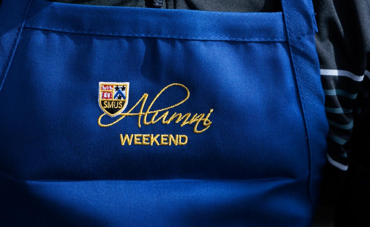 Alumni Weekend text is embroidered on to an apron worn by a Board of Governor for the annual pancake breakfast