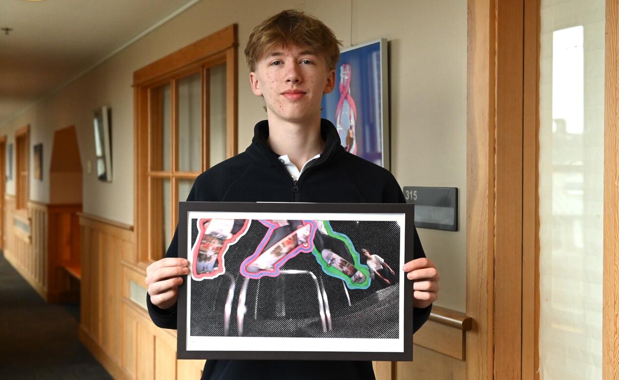 Cohen Labrecque holds up his artwork from his AP Art portfolio.