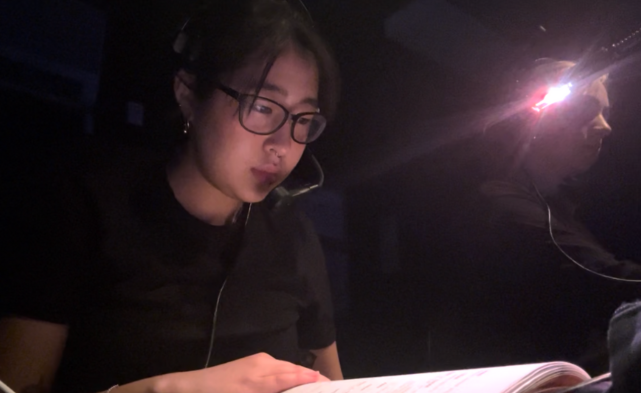Yule Choi behind the stages reading a script at the musical