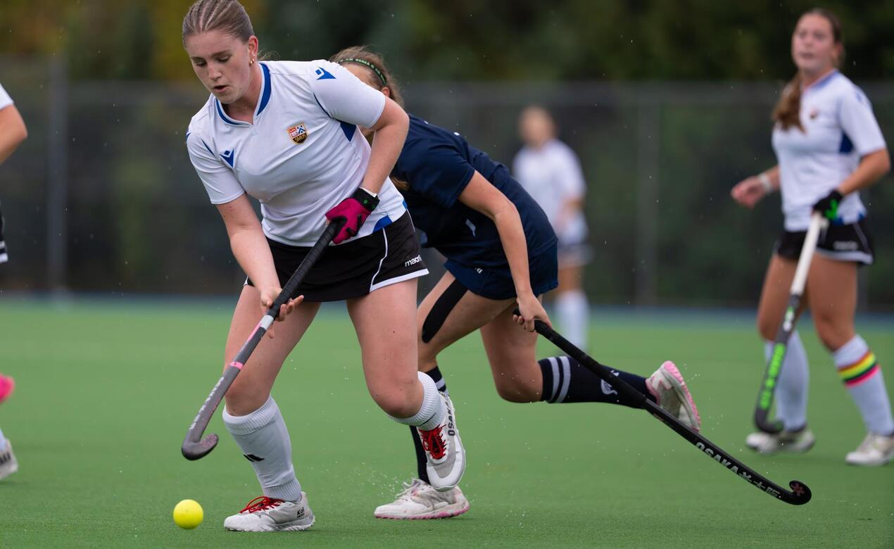 Isabel Thomson dribbles the ball in a field hockey game.