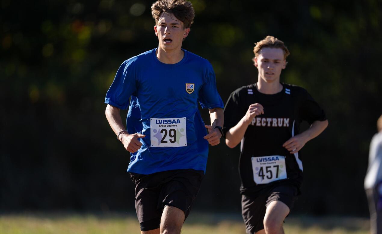 Finlay Hlannon races past a Spectrum cross-country runner