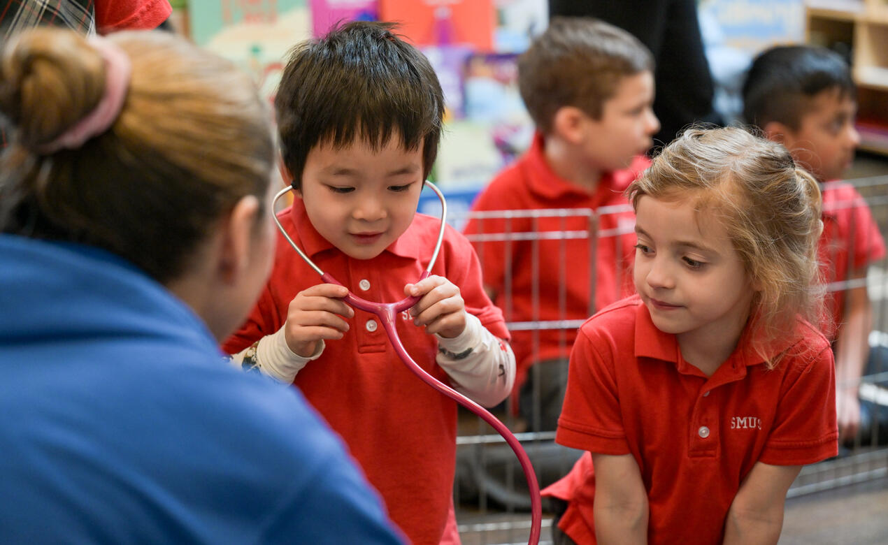 A Kindergarten student listens through a stethoscope