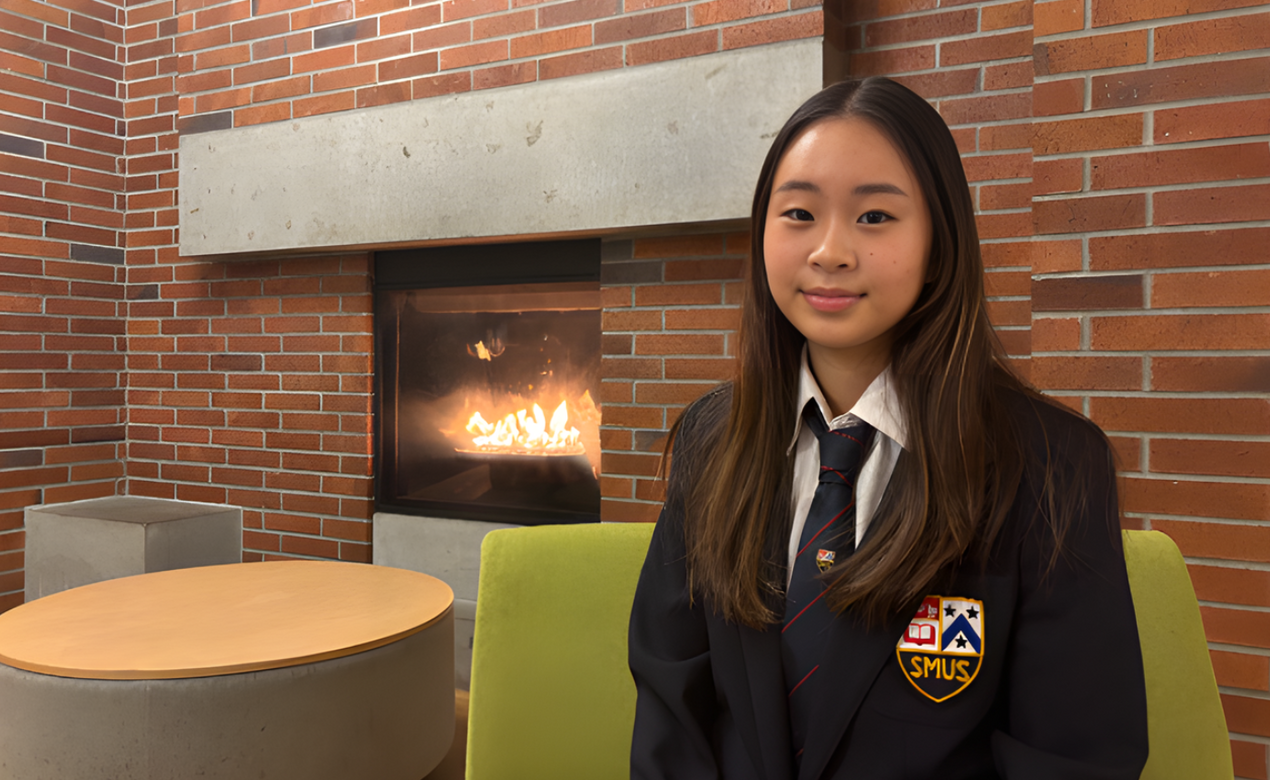 Kayler Kim sits by a fireplace at SMUS