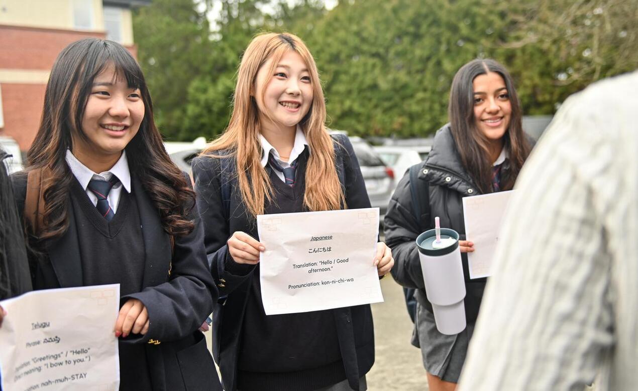 Students hold messages of greetings in different languages
