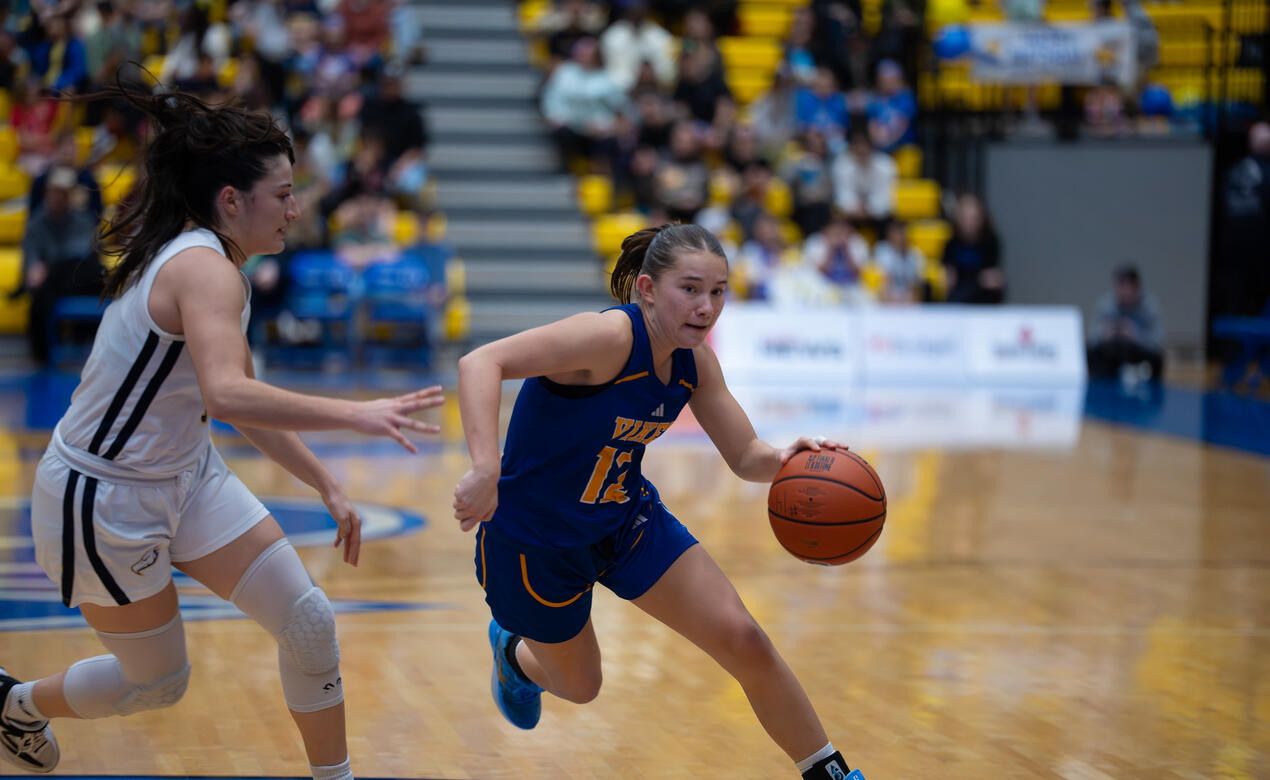 Avery Geddes dribbles up the court playing for the UVic Vikes