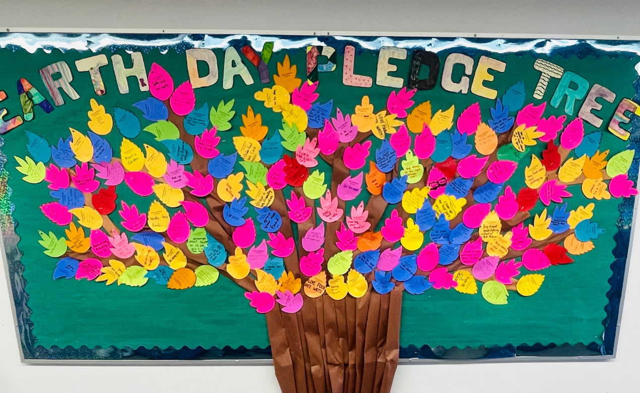 Middle School students create a tree with leaves sharing pledges to the planet