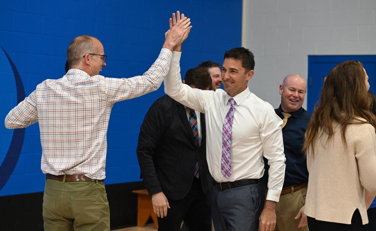 Eliot Anderson high fives Ian Farish after a staff tug of war in the gym.