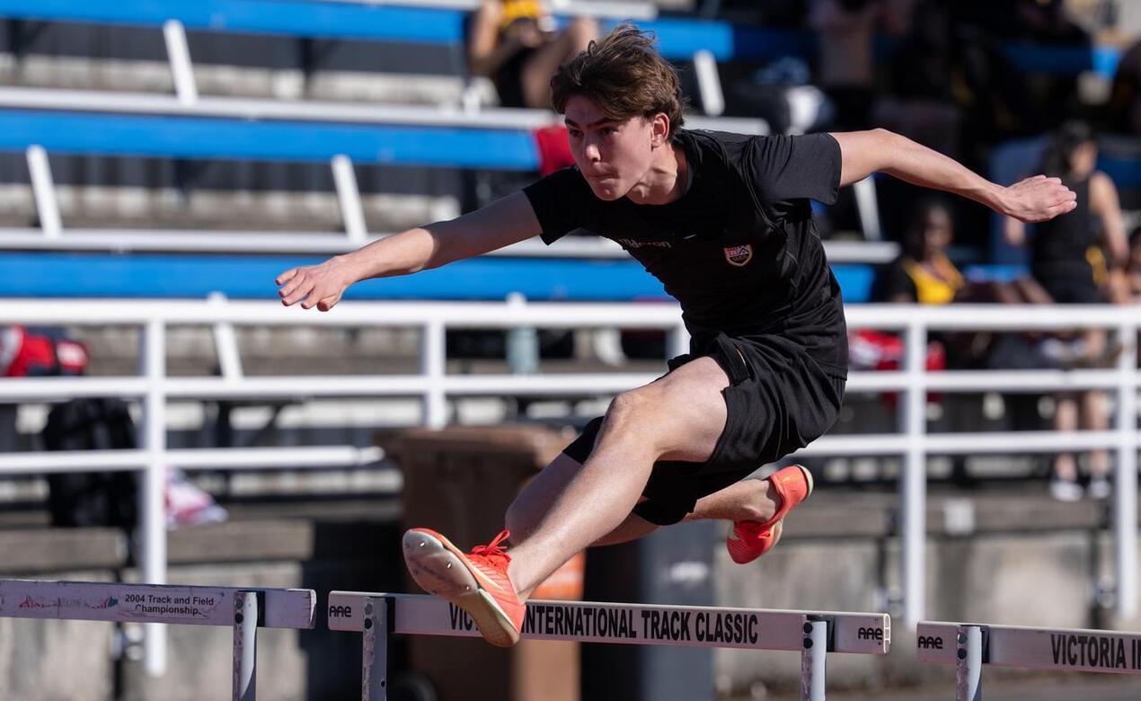 Will Hamilton clears a hurdle at Track and Field meet