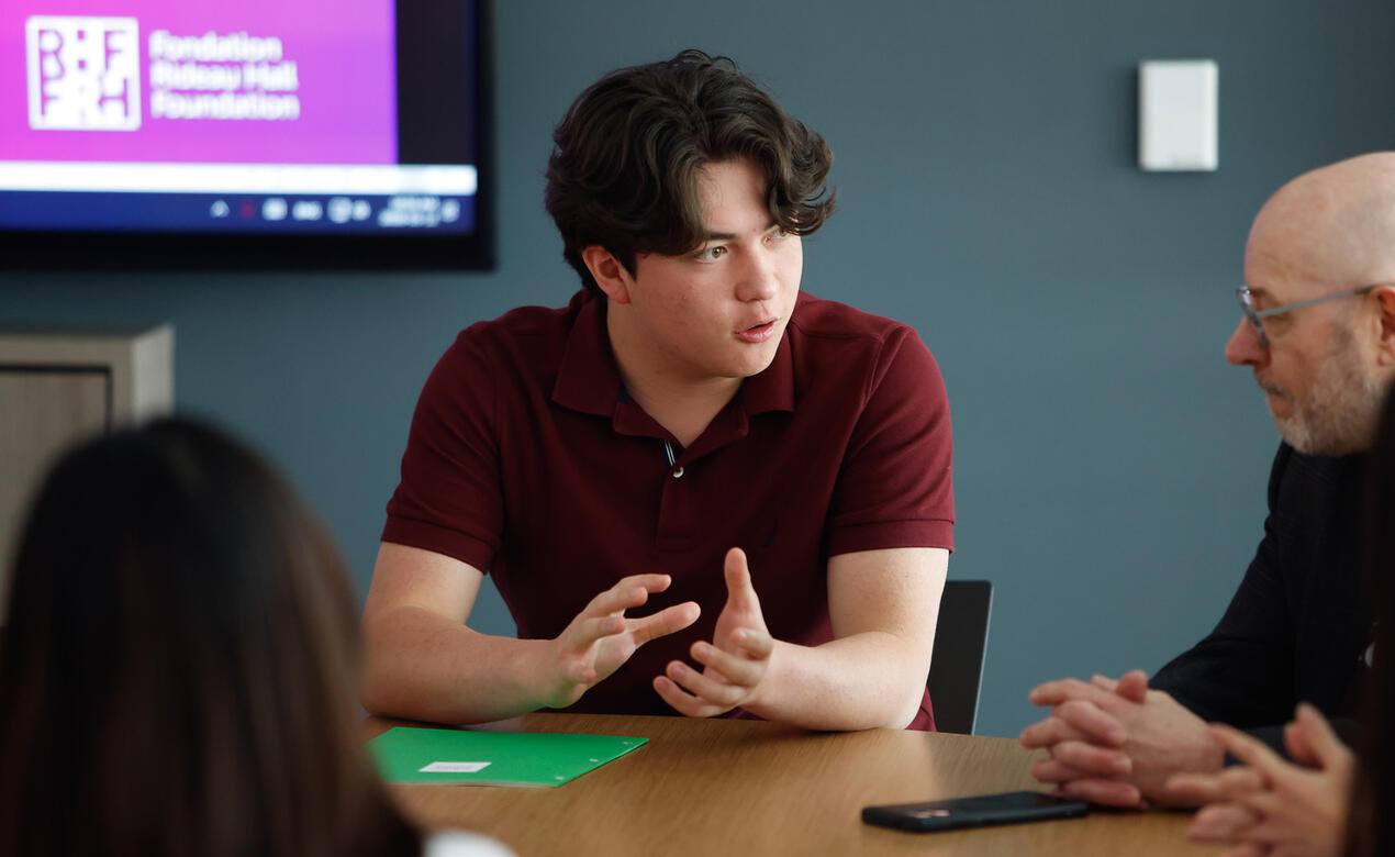 Liam Pope-Lau '27 speaking to group at table