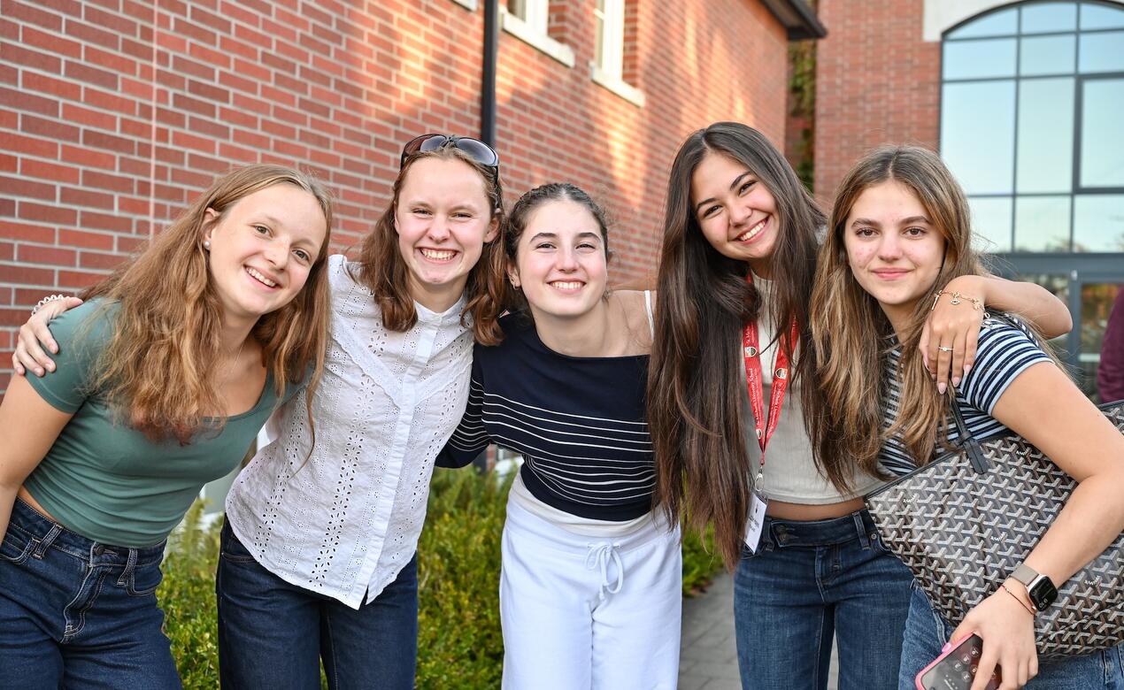 five students gather together to smile at the photo at New Boarder Orientation