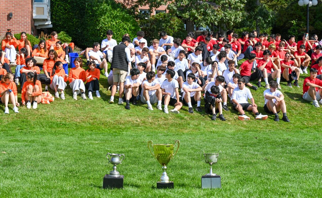 Three coveted House Games trophies sit on the field in front of the boarding community ready for House Games.