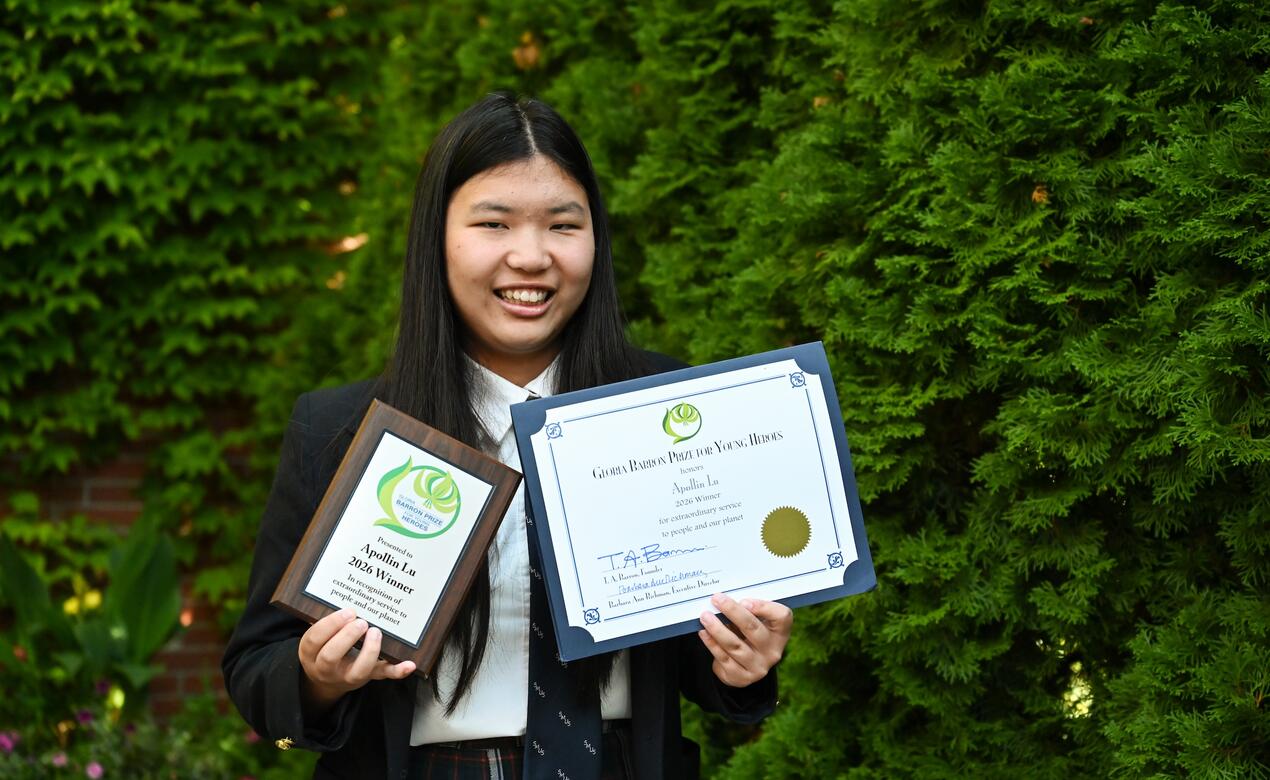 Apollin Lu stands with her awards. 