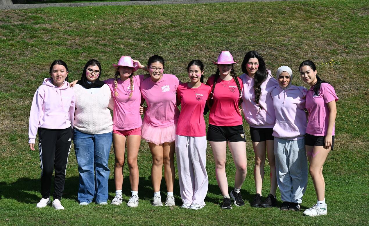 Grade 12 students in Winslow House stand for a photo in their pink shirts.
