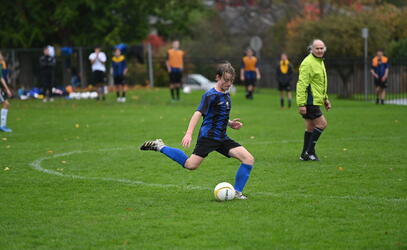 Junior Boys Soccer player kicking the ball