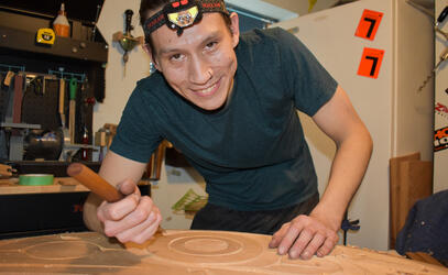 Indigenous carver, Dylan Thomas, working on a spindle whorl