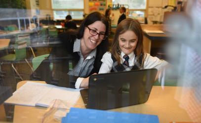 Junior School teacher and student working with a laptop