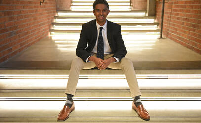 Alum Dawit Workie sits on the lit interior steps of the Sun Centre