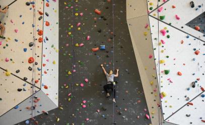 A student tackles an indoor climbing wall