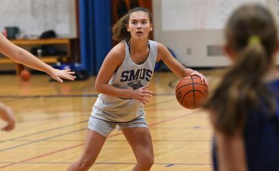 A Senior School athlete dribbles a basketball during a girls basketball practice.