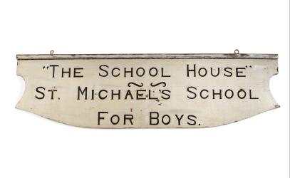 An old, white sign that reads "The School House - St. Michael's School for Boys".