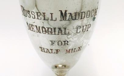 A detail of an old trophy that reads Russell Maddock Memorial Cup for Half Mile