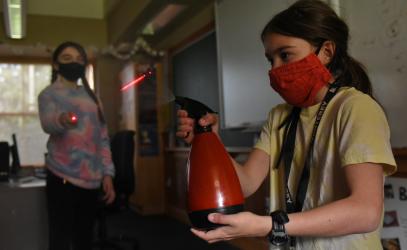 Students in Quantum Junior Camp learn about lasers using a red laser pointer and a spray bottle of water.