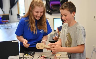 Two students in a digital fabrication summer camp work together to build a racecar