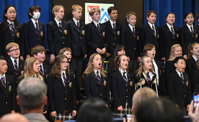 Grade 5 students perform a choir song in the Junior School gymnasium during the Closing Ceremony.
