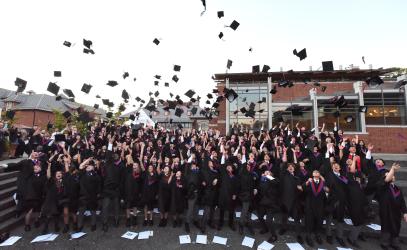 Students throw their caps in the air after graduation