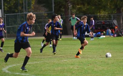 Members of the Junior Boys Soccer team run after a soccer