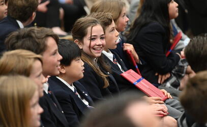 Student smiles as they graduate from the Junior School during Closing Ceremonies.