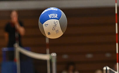 A volleyball flies over the net