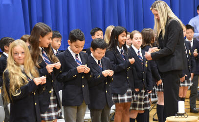 Junior School Director Becky Anderson performing the 'pinning' right of passage for Grade 5's in Monday's Leadership Assembly.