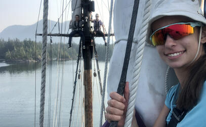 A student has a birds-eye view from the mast of a tall ship