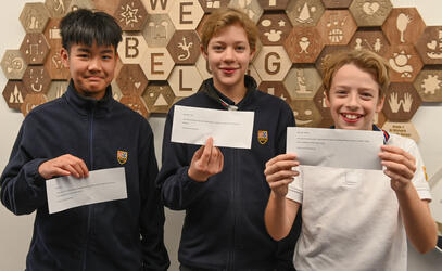3 students hold up notes of gratitude