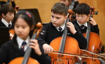 Grade 4 students playing cello at a concert
