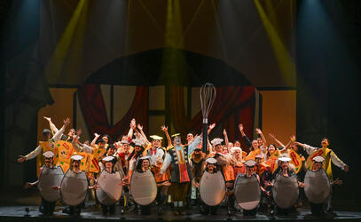 Students performing in egg costumes on stage