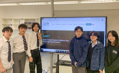 The CaYPT team stand next to a large computer screen