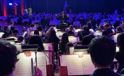 The Strings orchestra play in front of a crowded room