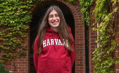 Ilona smiles whilst wearing her Harvard hoodie