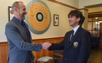 Alessandro shakes hands with Kevin Mennie on receiving the Indigenous Peoples Within Canada Award