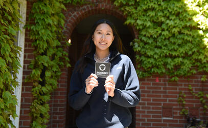 A student holds a Minerva sticker