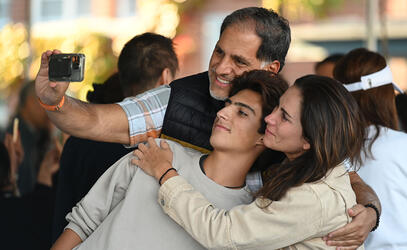 A family takes a selfie just before parting for the new school year