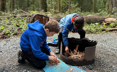 Two grade 5 students build a fire at Goldstream