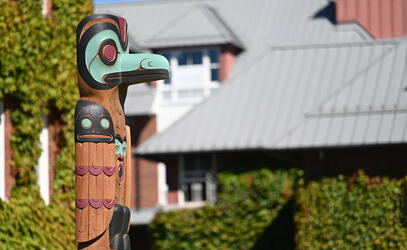 A Welcome Pole carved by Dylan Thomas with a representation of raven at the top stands tall on the SMUS campus